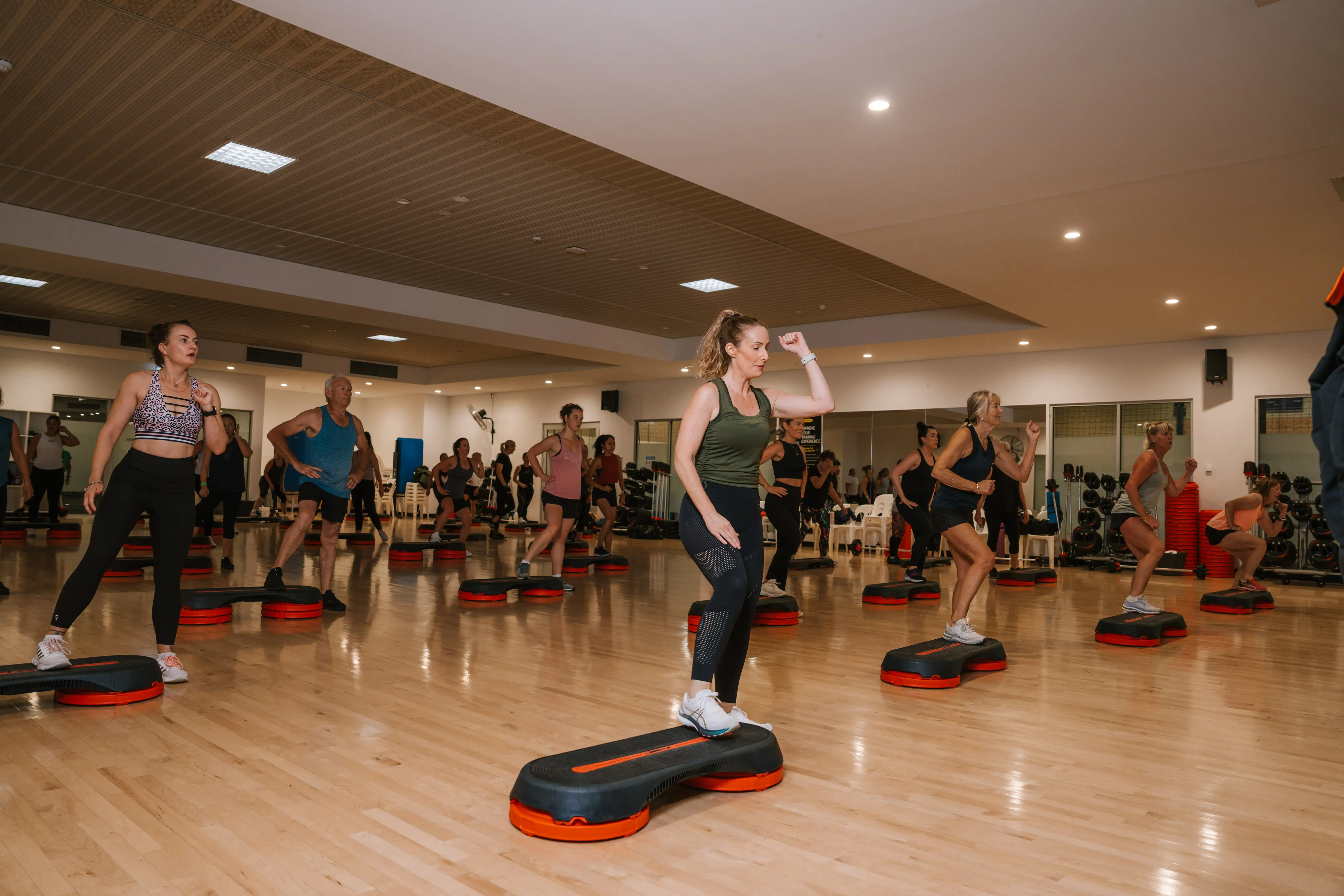 Gym group fitness step class.